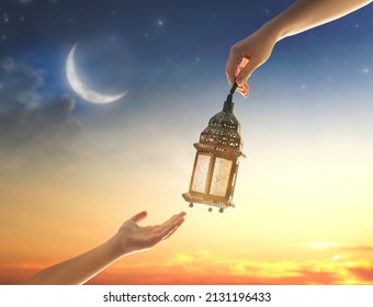 Ornamental Arabic lantern with burning candle glowing in hand. Festive greeting card, invitation for Muslim holy month Ramadan Kareem. - Shutterstock ID 2131196433