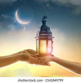 Ornamental Arabic lantern with burning candle glowing in hand. Festive greeting card, invitation for Muslim holy month Ramadan Kareem. - Shutterstock ID 2141849799