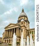 An ornamental water fountain sprays and splashes in front of the Illinois State Capitol Building in Springfield, Illinois, USA.