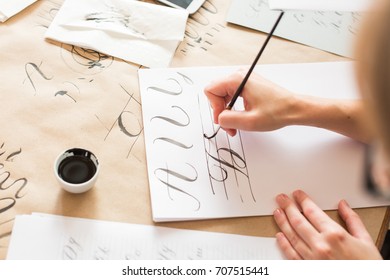 ornamentation, graphic design, education concept. woman preparing writing exercises for learning calligraphy. there is different types of lines and capital letters of russian alphabeth