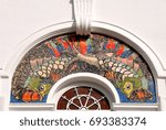 Ornate arched window in a colonial building in Malaysia with a colourful mosaic picture
of two koi fish