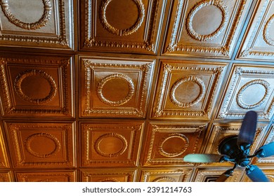 Ornate Bronze Tin Ceiling Tiles with Ceiling Fan in Vintage Interior - Powered by Shutterstock