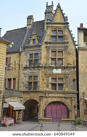 Ornate building in the medieval centre of Sarlat, Dordogne, France. With many interesting features such as leadlight windows, arched and colonaded entrance, with steep pitched roof