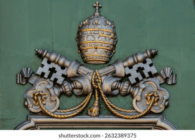 Ornate carving of Papal Tiara and crossed keys.