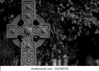 Ornate Celtic cross in black and white. Dark scene.