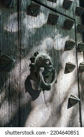 Ornate Door Knocker At The Merida Cathedral In Mexico. Mottled Light Shines On The Door.