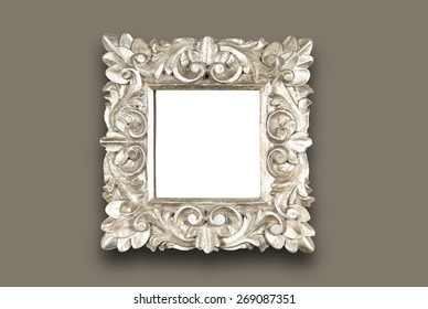 An Ornate Floral Design Square Wooden Frame Painted In Silver. Hung On Wall. With Clipping Path