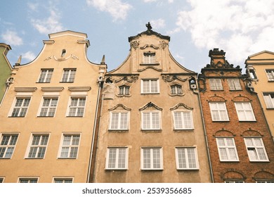 Ornate historic buildings with colorful facades and intricate architectural details, showcasing the unique charm of a European old town against a blue sky. - Powered by Shutterstock