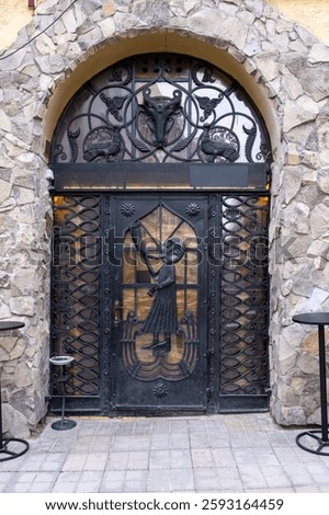 Ornate Medieval Wrought Iron Door in Stone Archway
