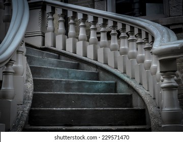 Ornate stairwell made of stone with wood spindles