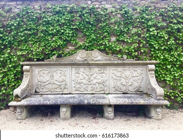 Ornate stone bench with ivy wall