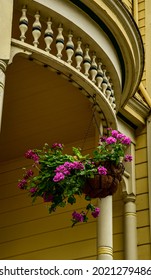 Ornate Victorian House Porch With Hanging Planter Geraniums Blooming Pink Flowers