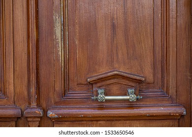 Ornate Vintage Handle On Triangle Shaped Frame Of Natural Wooden Door Panel. Shabby Wood Texture. Architectural Details Of Paris Door Of Ancient Building In France.