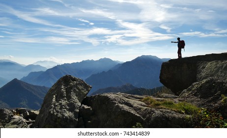 OROBIE MOUNTAINS, ITALY - CIRCA JUNE 2018: a hiker stands on a big boulder in the Orobie mountains and admires the beauty of  nature. - Shutterstock ID 743414839