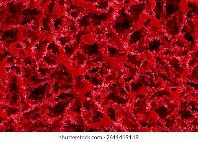 a orous structural surface close-up, red background, grinding wheel, macro insert of porous spongy surface