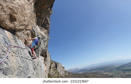 Orpierre, Hautes Alpes- Drome-France -  april 13 2022: rockclimber climbing the steep cliffs towering Orpierre a small village in France                             