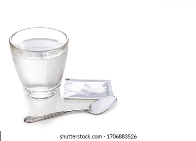 ORS Or Oral Rehydration Salt With Glass Of Water, Sachet And Spoon With White Background