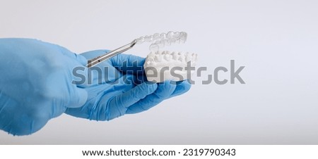 Orthodontic dental theme on blue background.Transparent invisible dental aligners or braces aplicable
