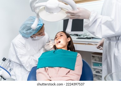 Orthodontist doctor examine tooth to woman patient at dental clinic. Attractive young girl with braces lying on dental chair, getting dental treatment from dentist during procedure service in hospital - Powered by Shutterstock