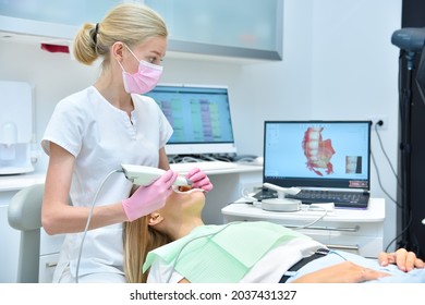 Orthodontist scaning patient with dental intraoral scanner and controls process on laptop screen. Prosthodontics and stomatology concept.