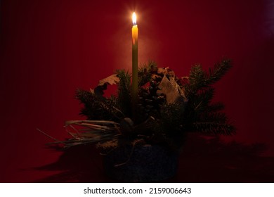 Orthodox Christmas burning candle on dark background with decorations, pine tree, oak tree leaves, pine cone - Powered by Shutterstock