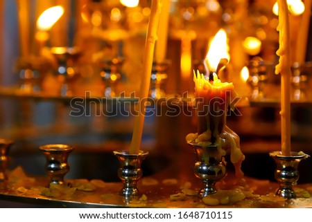  The Orthodox Church. Christianity. Many burning candles in candlesticks during liturgy in the Orthodox Church.