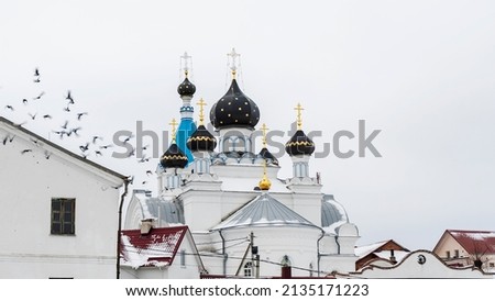 Orthodox church and the flying pigeons. Allegory of faith and freedom. Flock of pigeons flying around the dome. Worship concepts. Space for text.