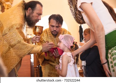 Orthodox Euharist Ceremony. Priest Makes Child's Communion. AUGUST 2017. RUSSIA, RYLSK.