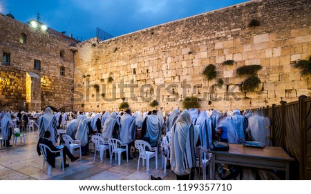 Orthodox Jewish men in Tallit prayer shawls standing from before dawn for Shacharit sunrise prayer at the Western/Wailing Wall or Kotel, the holiest place in Judaism; Jerusalem Israel