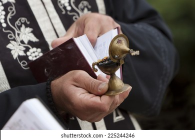 Orthodox Priest Held Holy Book And Burning Church Incense.