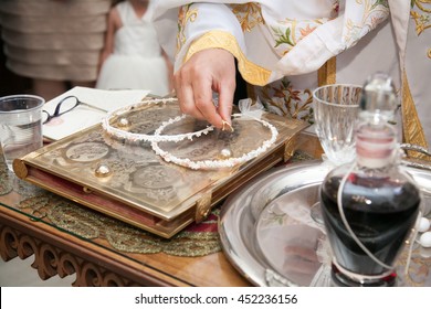 Orthodox Priest Holding The Crowns In Front Of Groom And Bride