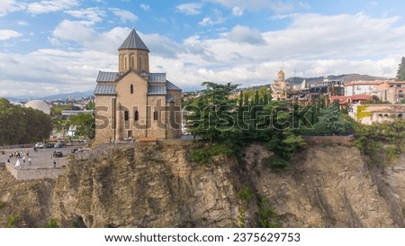 Orthodox temple on a rock in Georgia. Metekhi Cathedral in Tbilisi. Religion of Georgia. Aerial View of Tbilisi by Drone. Traveling in Georgia, Background of Tbilisi in the fall in September.Cityscape