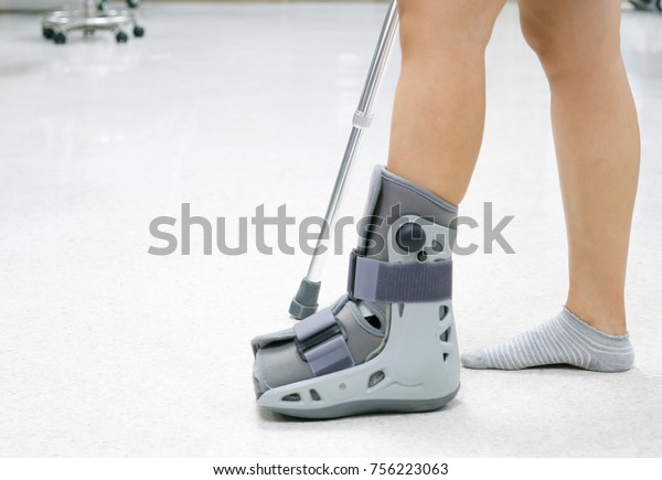 Orthopaedic Boot and crutch to a Patient. Image with\
copy space for text