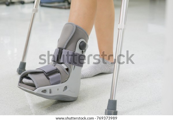 Orthopaedic Boot and crutch to a Patient.\
medical orthopedic\
concept.
