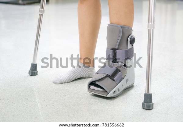 Orthopaedic Boot and crutch to a Patient.\
medical and orthopedic\
concept.