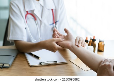 Orthopaedic Doctor Doing Physical Examination In The Patient With Wrist Pain At The Clinic. Pain From Tendonitis And Sport Injury. Medical And Physical Therapy Concept.