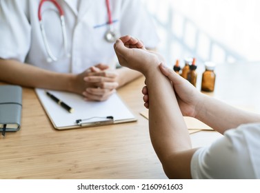 Orthopaedic Doctor Doing Physical Examination In The Patient With Wrist Pain At The Clinic. Pain From Tendonitis And Sport Injury. Medical And Physical Therapy Concept.