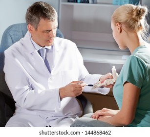 Orthopedic Doctor In His Office With The Model Of The Feet