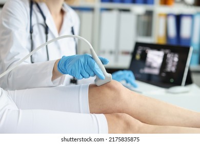 Orthopedic doctor makes ultrasound examination of tpatient knee in clinic - Powered by Shutterstock