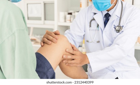 The orthopedic doctor or surgeon in white gown examined the patient with knee pain problem.White clean table or bed with blur background.Knee ligament or meniscus sport injury.Orthopaedic unit. - Shutterstock ID 2312440399