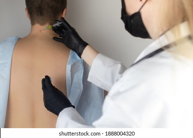 An orthopedic surgeon gives an injection in the cervical vertebrae. Treatment of osteoarthritis with hormonal drugs or drugs based on hyaluronic acid. Help with diseases that damage the cartilage