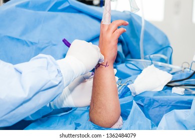 Orthopedic Surgeon Marking The Surgical Site Just Before Performing A Wrist Arthroscopy On A Male Patient