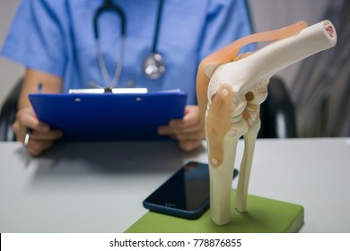 An orthopedic surgeon reads a patient's knee replacement report for analysis and guidelines for postoperative treatment and allows the patient to live a normal life. medical and orthopedic concept. - Shutterstock ID 778876855