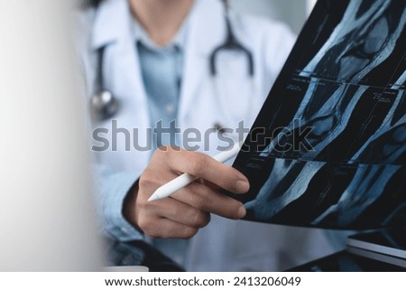Orthopedics surgeon doctor examining patient's knee joint x-ray films, MRI bone, ct scan in at radiology orthopedic unit in hospital. knee joint film x ray, close up