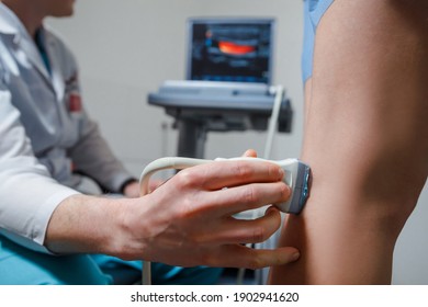 Orthopedist doctor doing ultrasound examination of patient's leg veins in his office. Young woman passing ultrasound scan in clinic. - Powered by Shutterstock