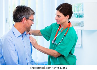 Orthopedist Doctor Examining Shoulder Of Patient In Surgery