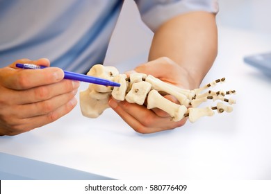 Orthopedist Doctor In His Office With Patient And Model Of Foot