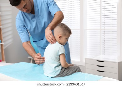 Orthopedist examining child's back in clinic. Scoliosis treatment - Powered by Shutterstock