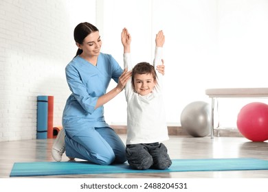 Orthopedist working with little boy in hospital gym - Powered by Shutterstock