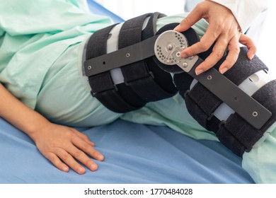 orthopidist adjust angle of knee brace that inserted to the leg of patient after endoscopic surgery for ligament repairing. healthcare and medical concept